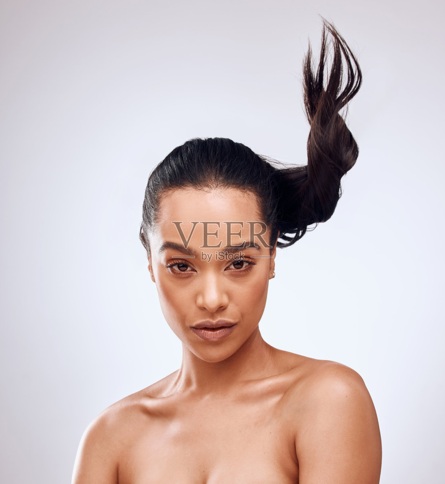 一个美丽的年轻女子在灰色背景下摆姿势的工作室肖像照片摄影图片