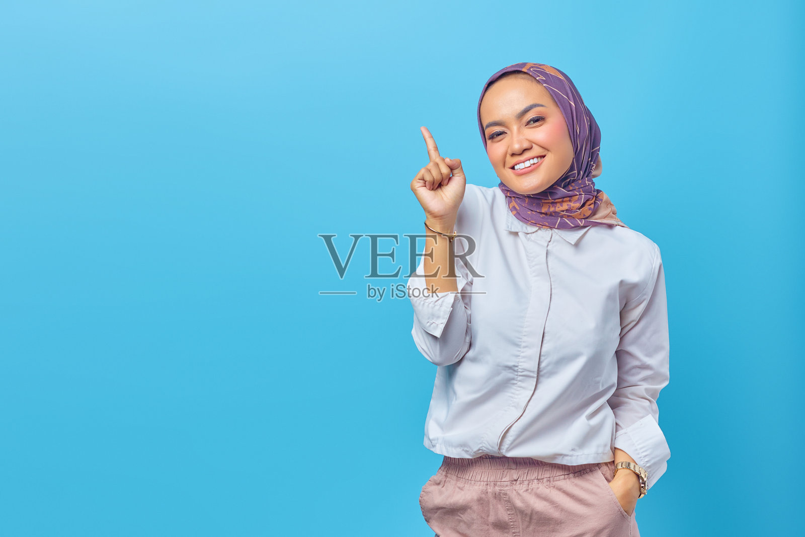 美丽的亚洲女人微笑并指向空白照片摄影图片