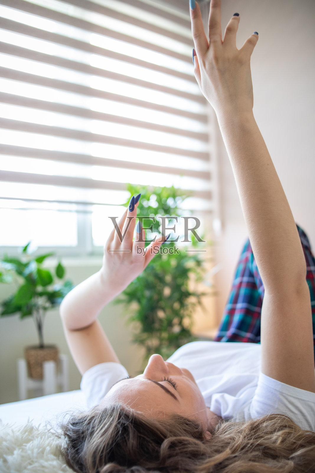 一个美丽开朗的女人在卧室的床上度过整个上午。照片摄影图片