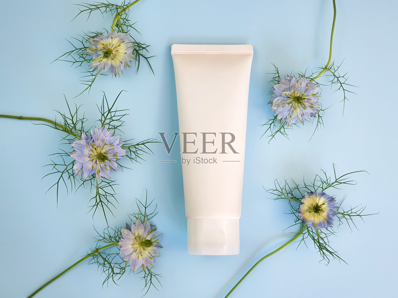 无品牌白色挤压瓶化妆品奶油管和圆形框架边界的蓝色奈洁拉花柔和的蓝色背景。用于药品或化妆品品牌的塑料管-洗发水，凝胶，护肤品照片摄影图片