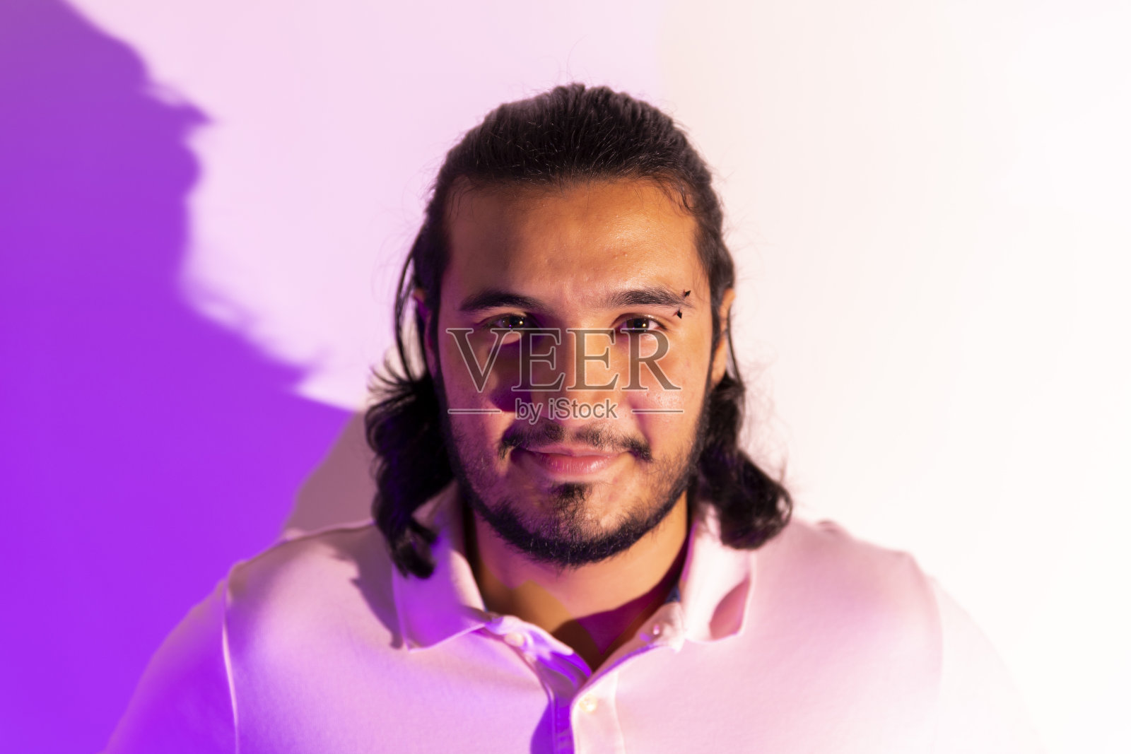 画室里一个年轻人的肖像，用五颜六色的灯光照片摄影图片