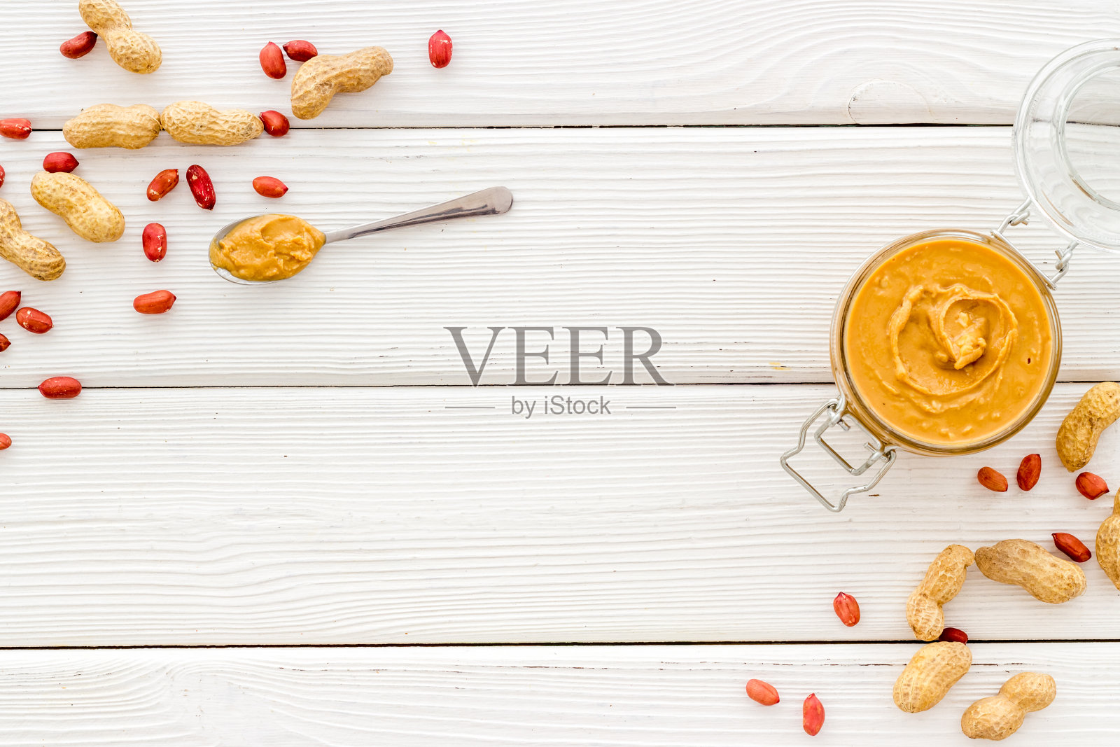 奶油花生酱在玻璃罐中与坚果，俯视图照片摄影图片