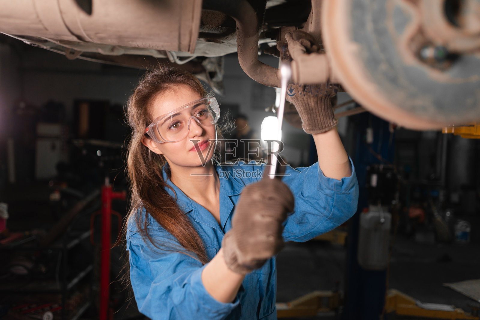 修车厂在引擎盖下工作的技工照片摄影图片