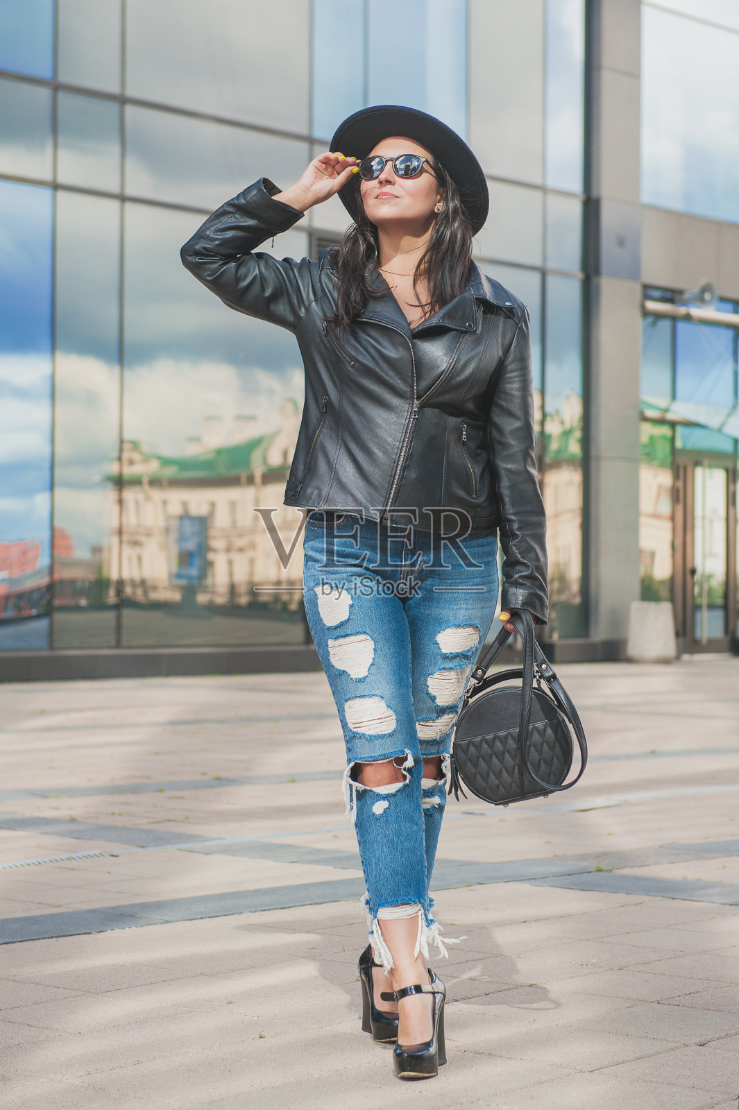 城市建筑背景的镜子墙上美女照片摄影图片