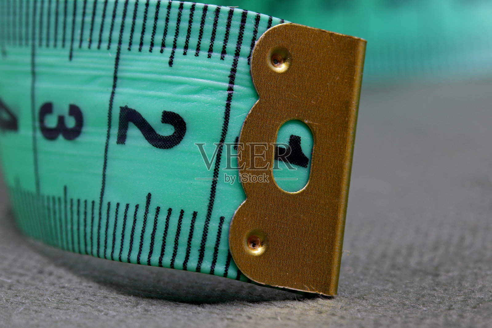 绿色卷尺在织物背景上照片摄影图片