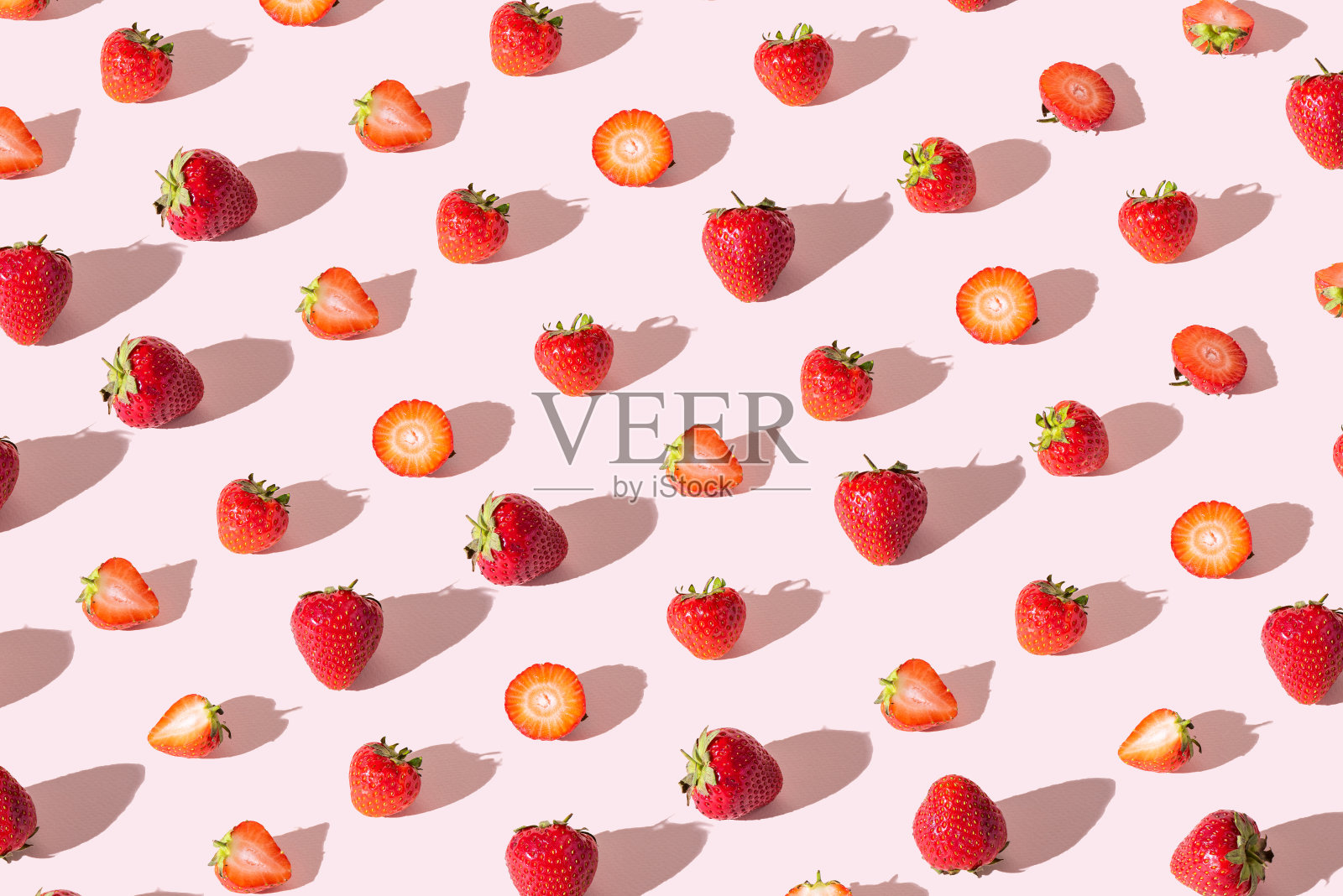 彩色图案的草莓整个和削减在粉红色的背景。从以上观点。照片摄影图片