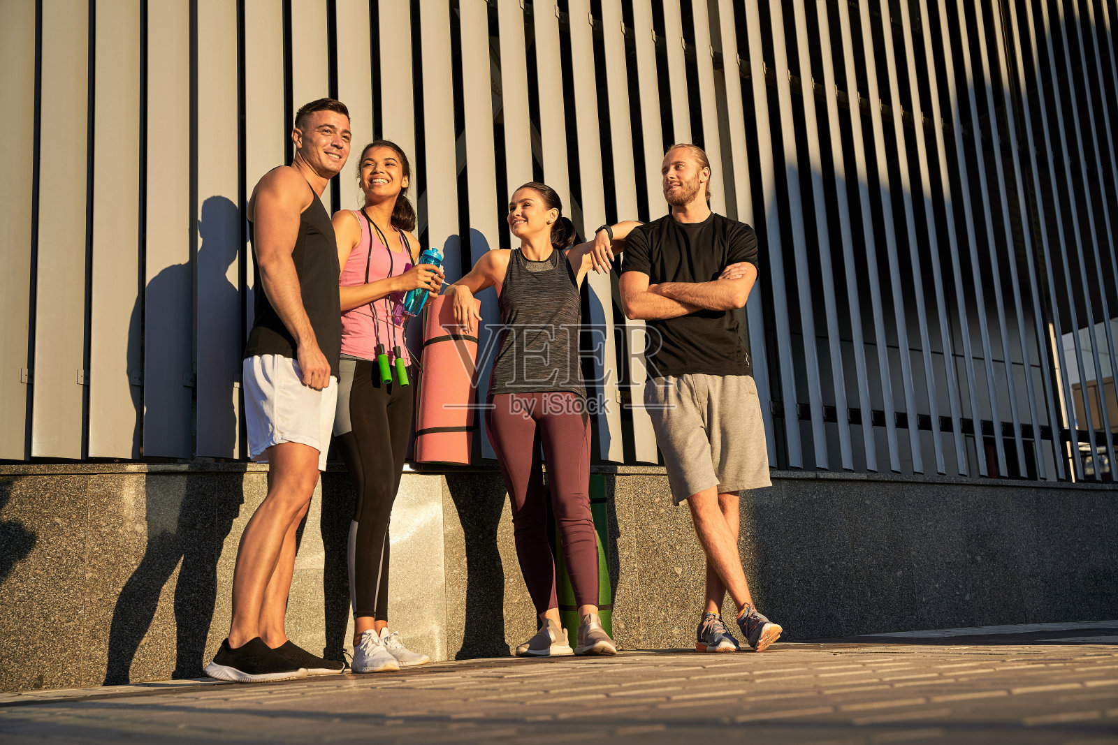 四名运动员在训练前站在街上照片摄影图片