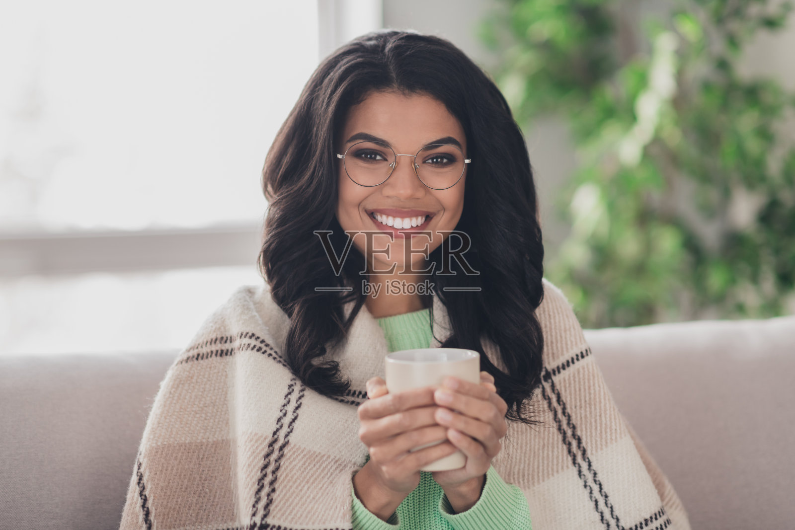 年轻迷人的黑人女人的照片快乐积极的微笑舒适享受热咖啡早上回家坐在沙发上照片摄影图片