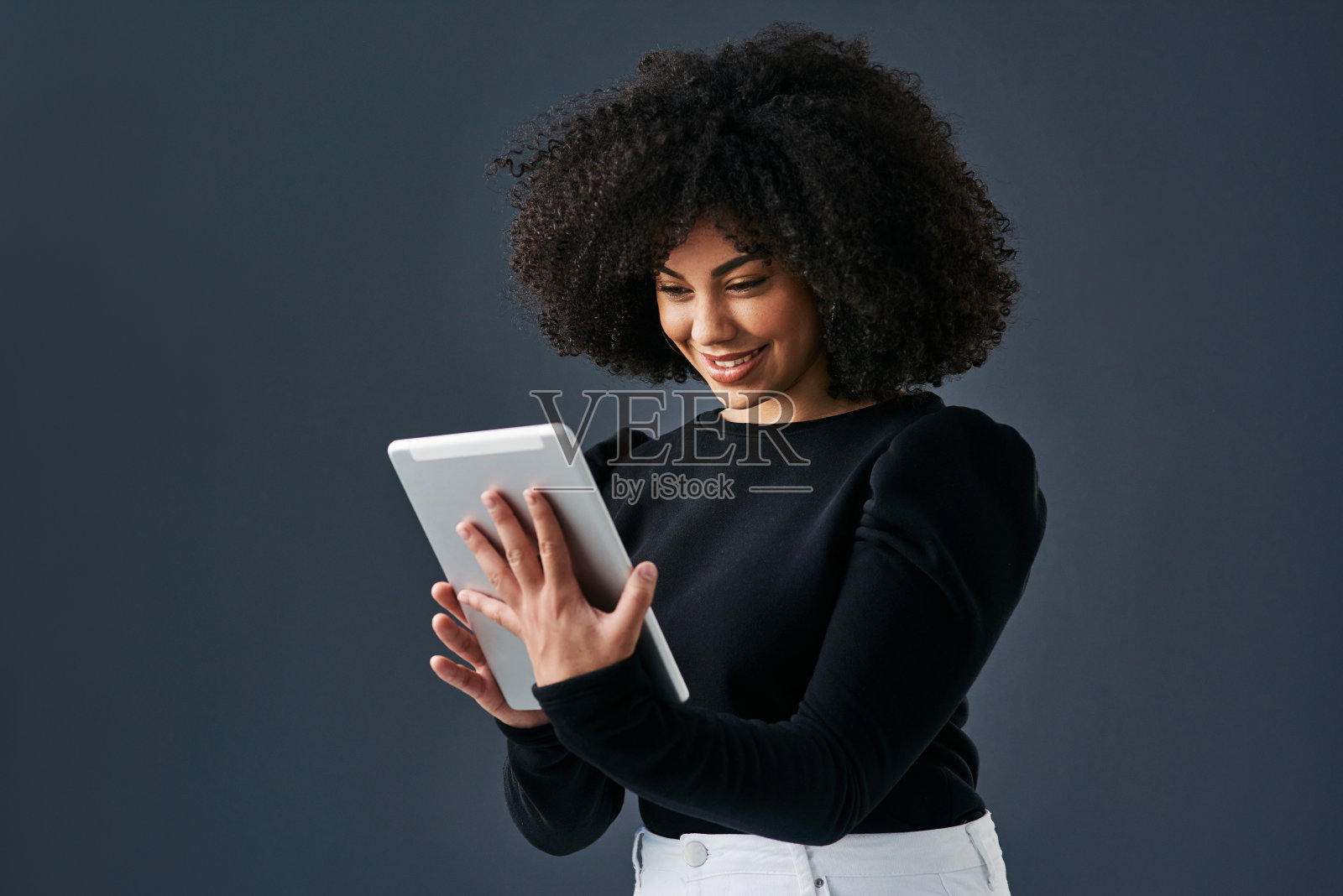 一名年轻的女商人在演播室背景下使用数码平板电脑照片摄影图片