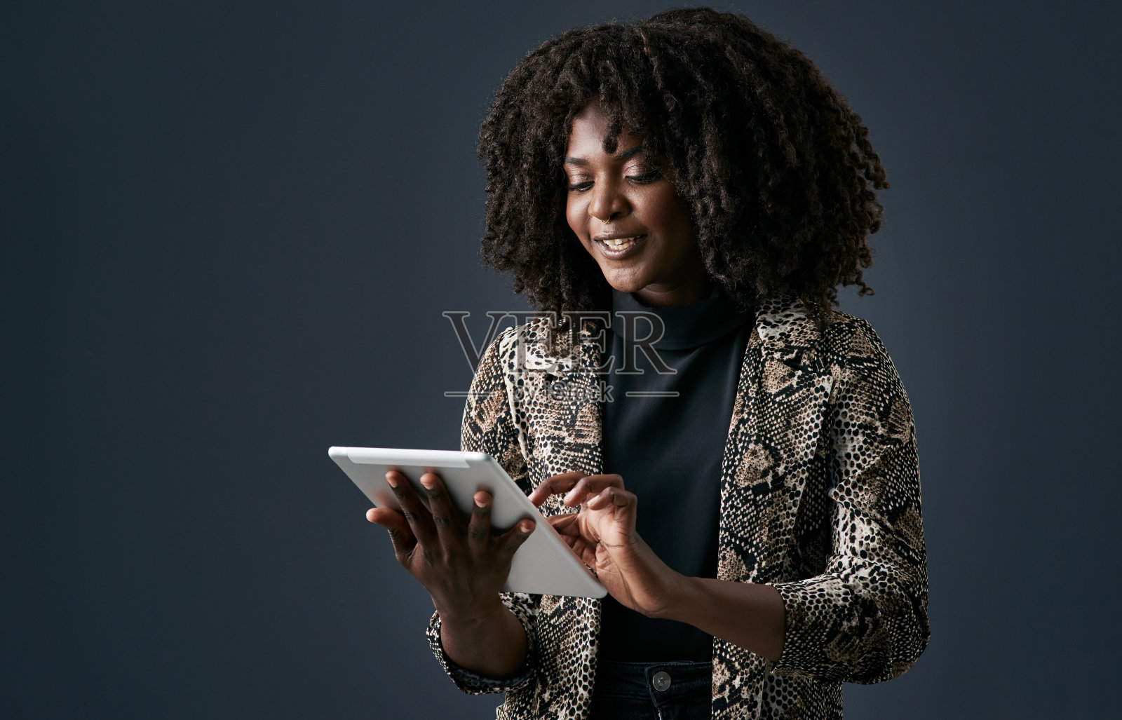 一名年轻的女商人在演播室背景下使用数码平板电脑照片摄影图片