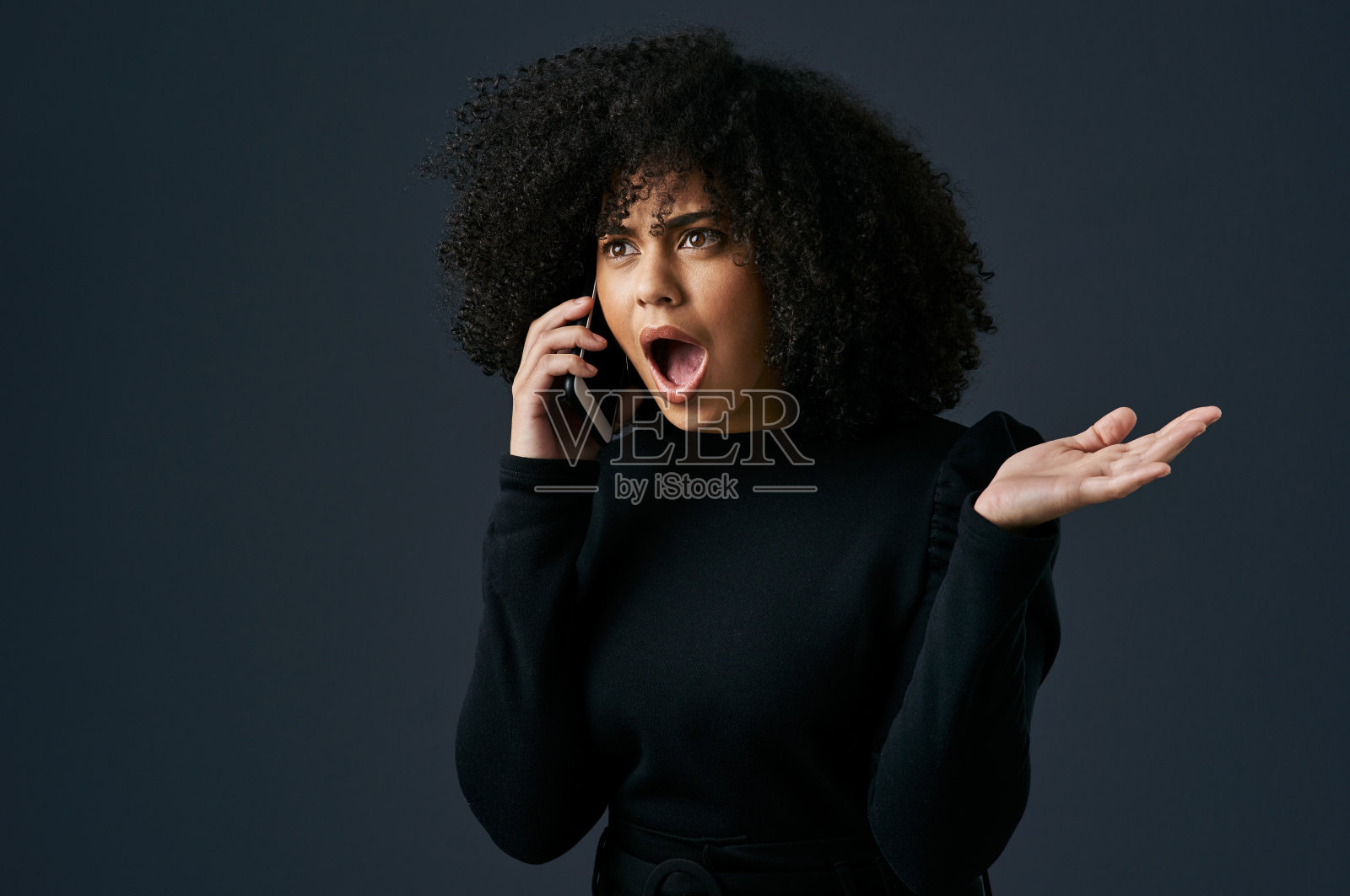 一名年轻的女商人在工作室背景下使用智能手机照片摄影图片