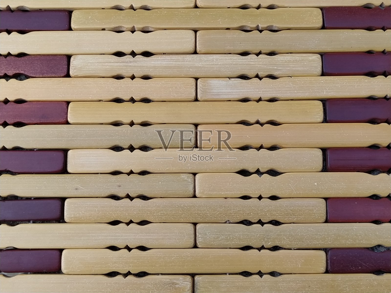 地毯是在炎热的天气下的垫子。针织加工过的圆角木棒。特写镜头。黄色、棕色和米色。边点燃。传统的竹垫纹理。照片摄影图片