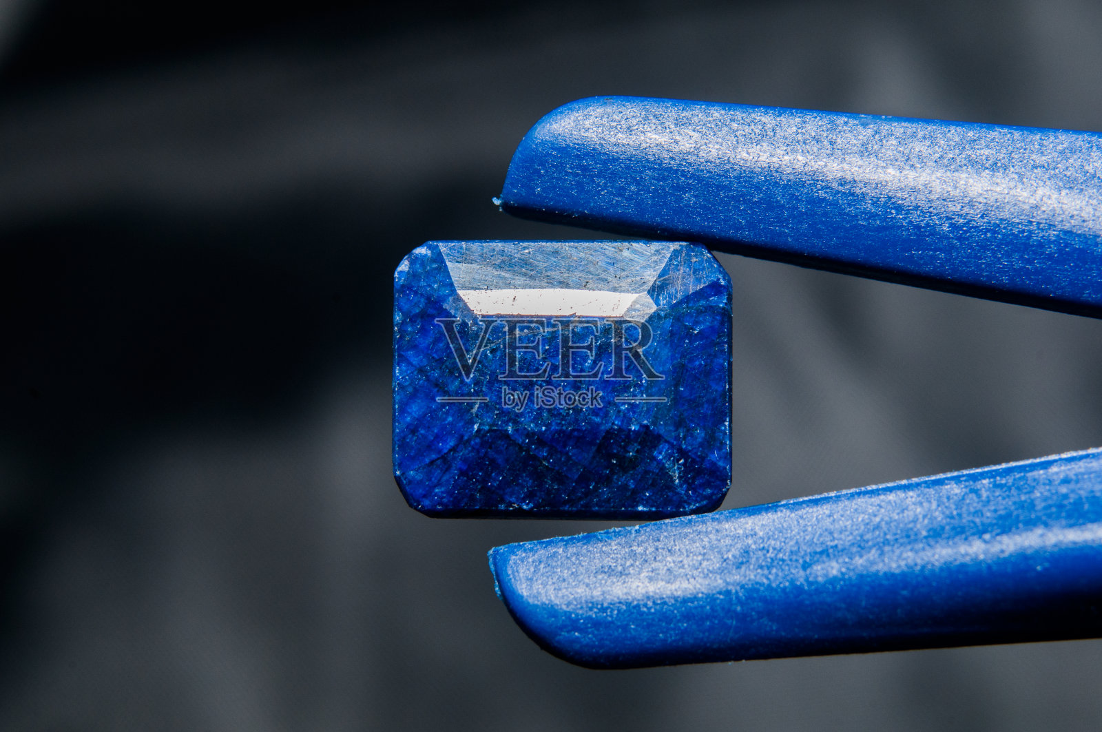 黑色背景下的手柄是蓝色的蓝宝石照片摄影图片