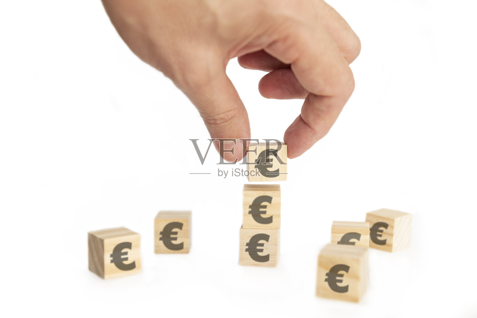 业务增长，增加利润，增加收入或节约观念。带有欧洲符号的木块排列成楼梯形状，一名男子举着顶部的木块照片摄影图片