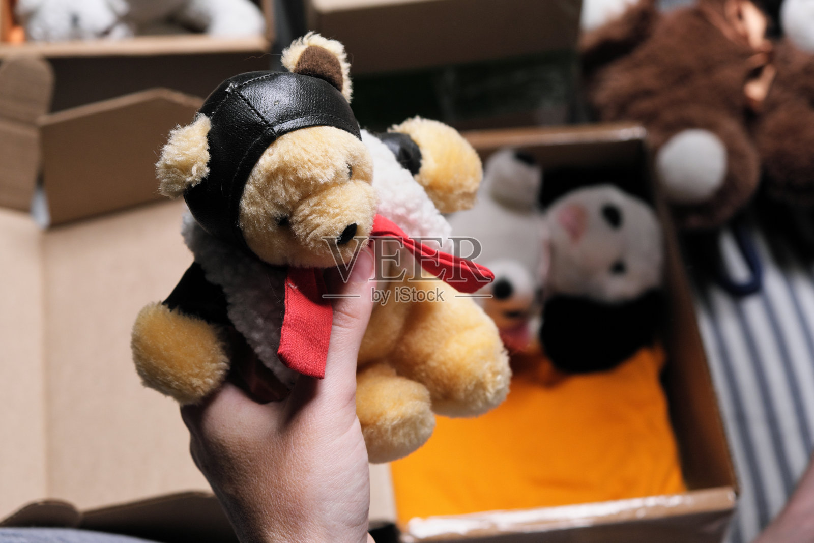 一个女人正坐在床上，装着要捐赠的毛绒玩具照片摄影图片