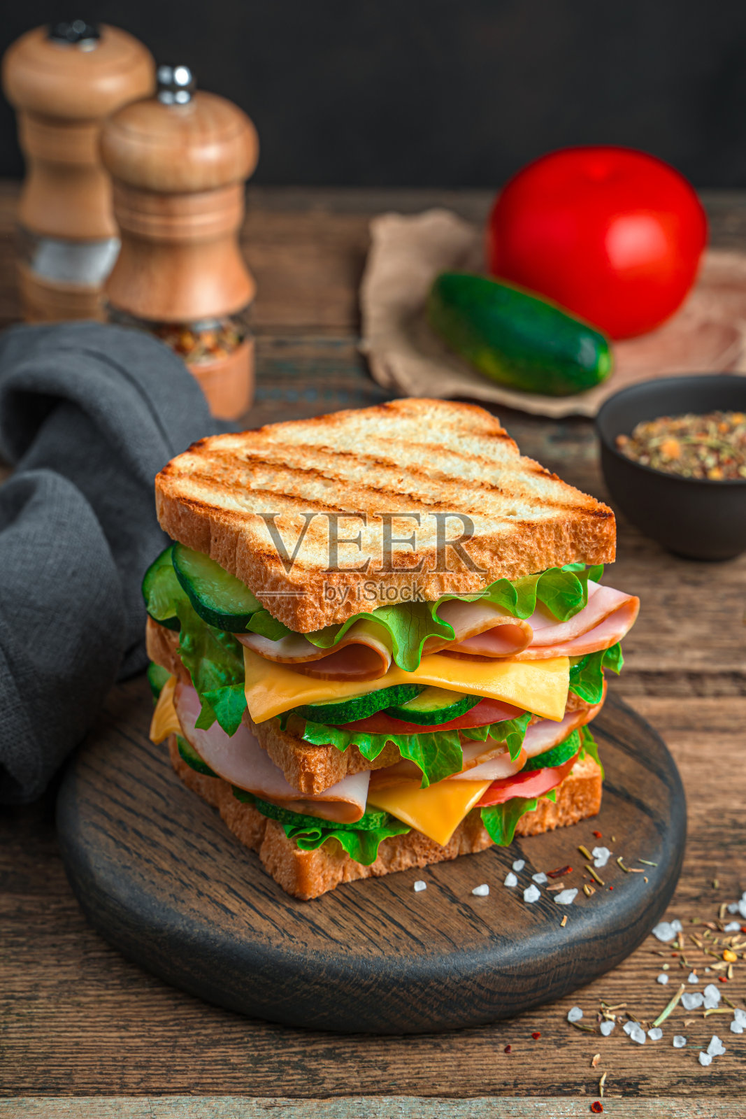 木制背景的大三明治，上面有烤面包、火腿、奶酪和新鲜蔬菜照片摄影图片