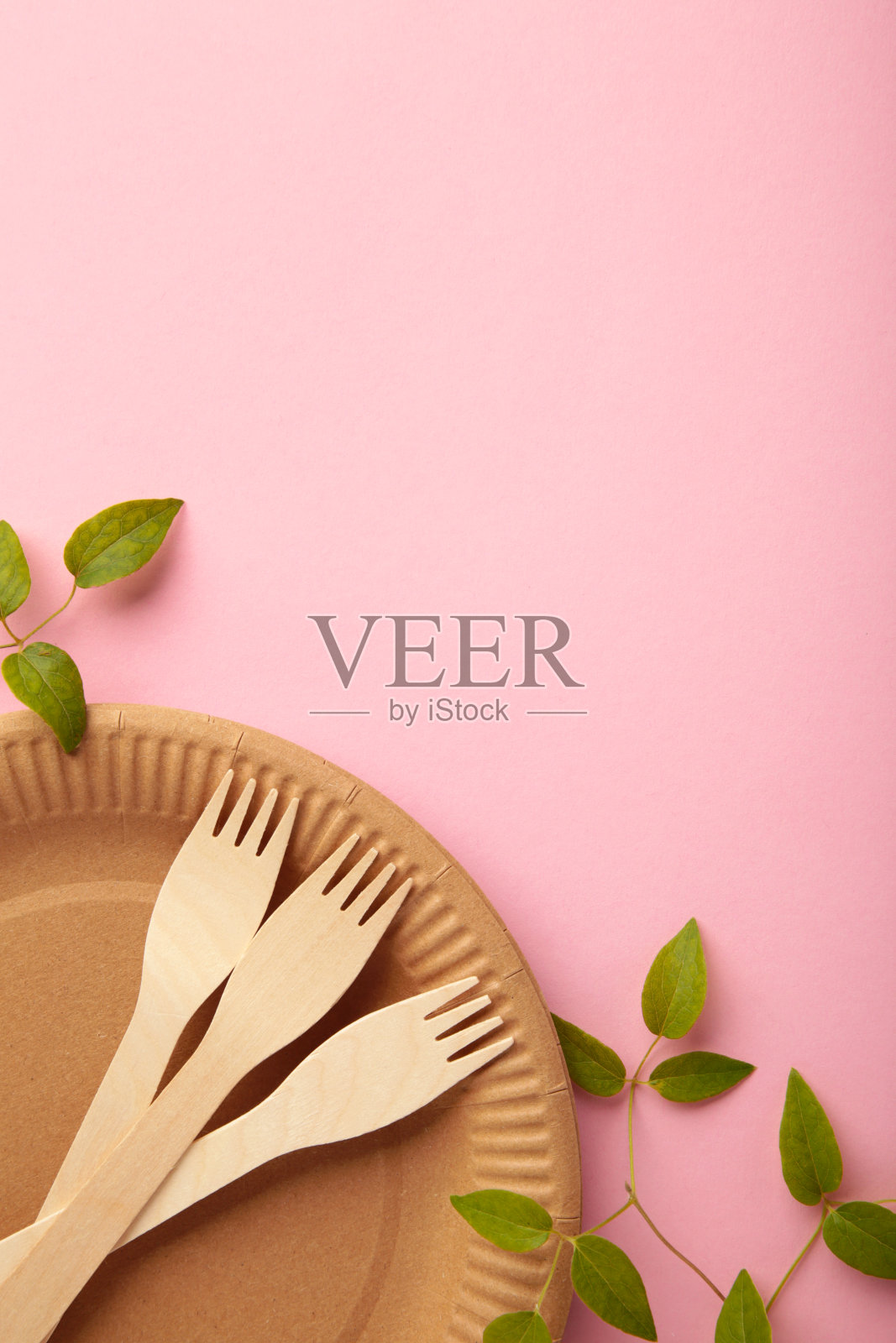 绿色绿色的一次性环保盘子，粉红色的背景。零浪费，环保，无塑料背景。垂直图照片摄影图片