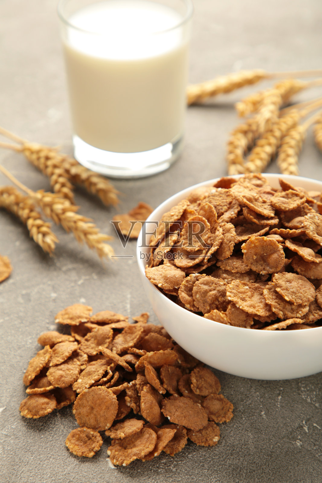 灰色背景上的脆玉米片和牛奶。垂直图照片摄影图片
