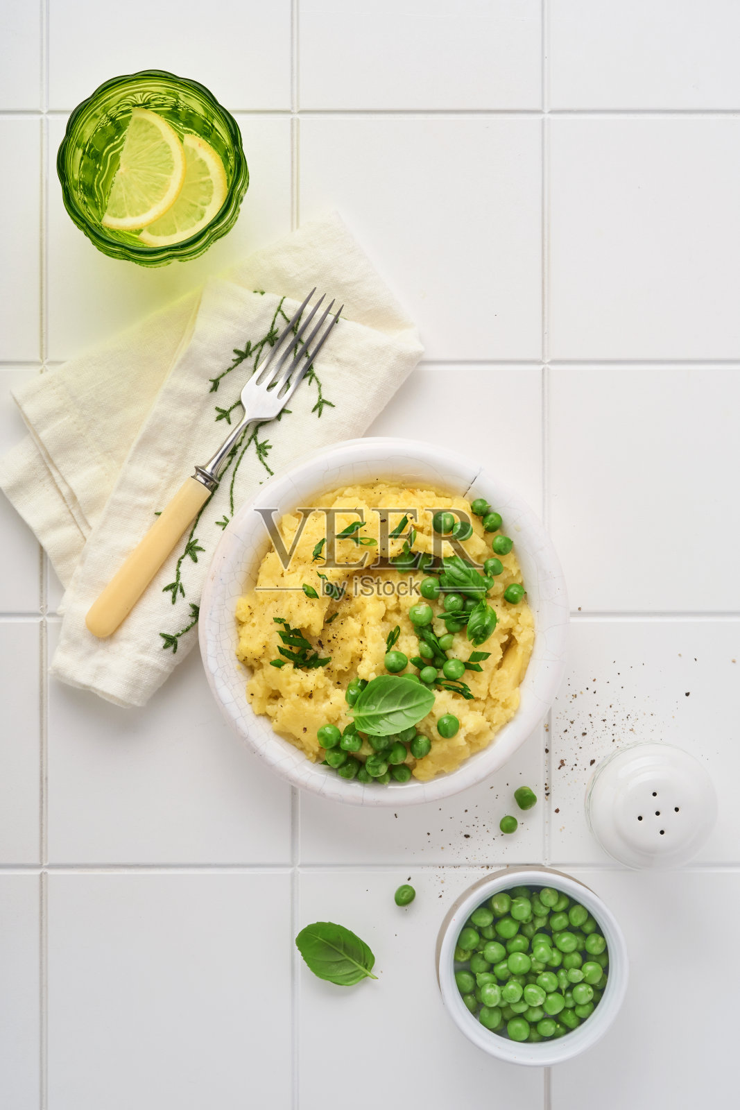 土豆泥，黄油，青豆，洋葱，罗勒在白色瓷砖背景上。俯视图与关闭。照片摄影图片