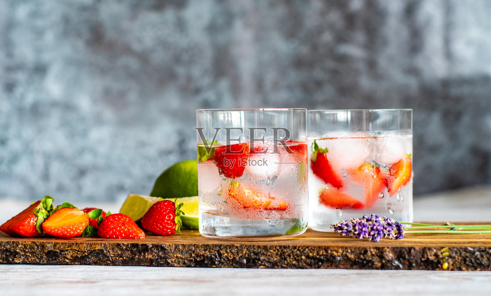 新鲜水果夏季饮料草莓，酸橙和冰块放在木桌上照片摄影图片