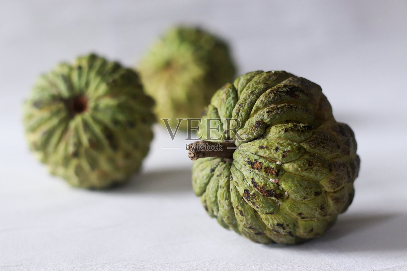 番荔枝是一种绿色的圆锥形水果，果皮坚韧，果肉柔滑甜美。它也被称为奶油苹果。照片摄影图片