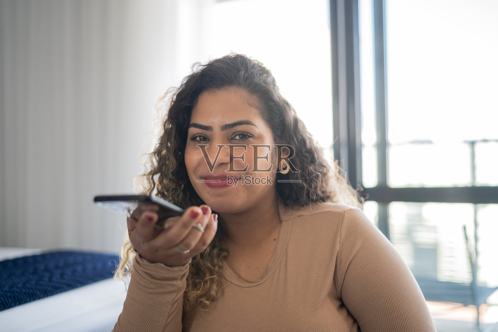 一名中年女性在家里用智能手机发送音频信息照片摄影图片