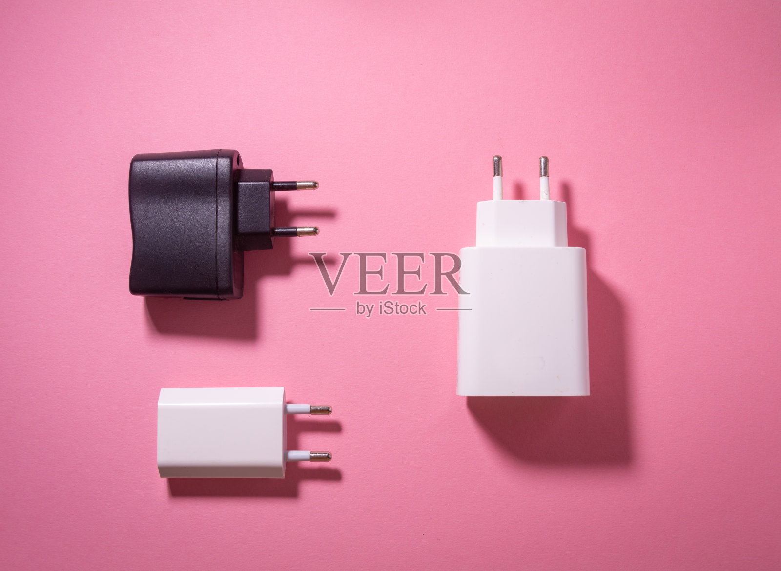 白色和黑色usb充电块在粉红色的背景照片摄影图片