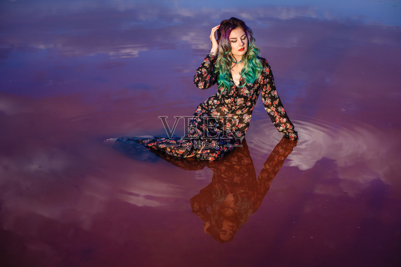 一个性感的女人在粉红色的湖水旁的沙滩上照片摄影图片