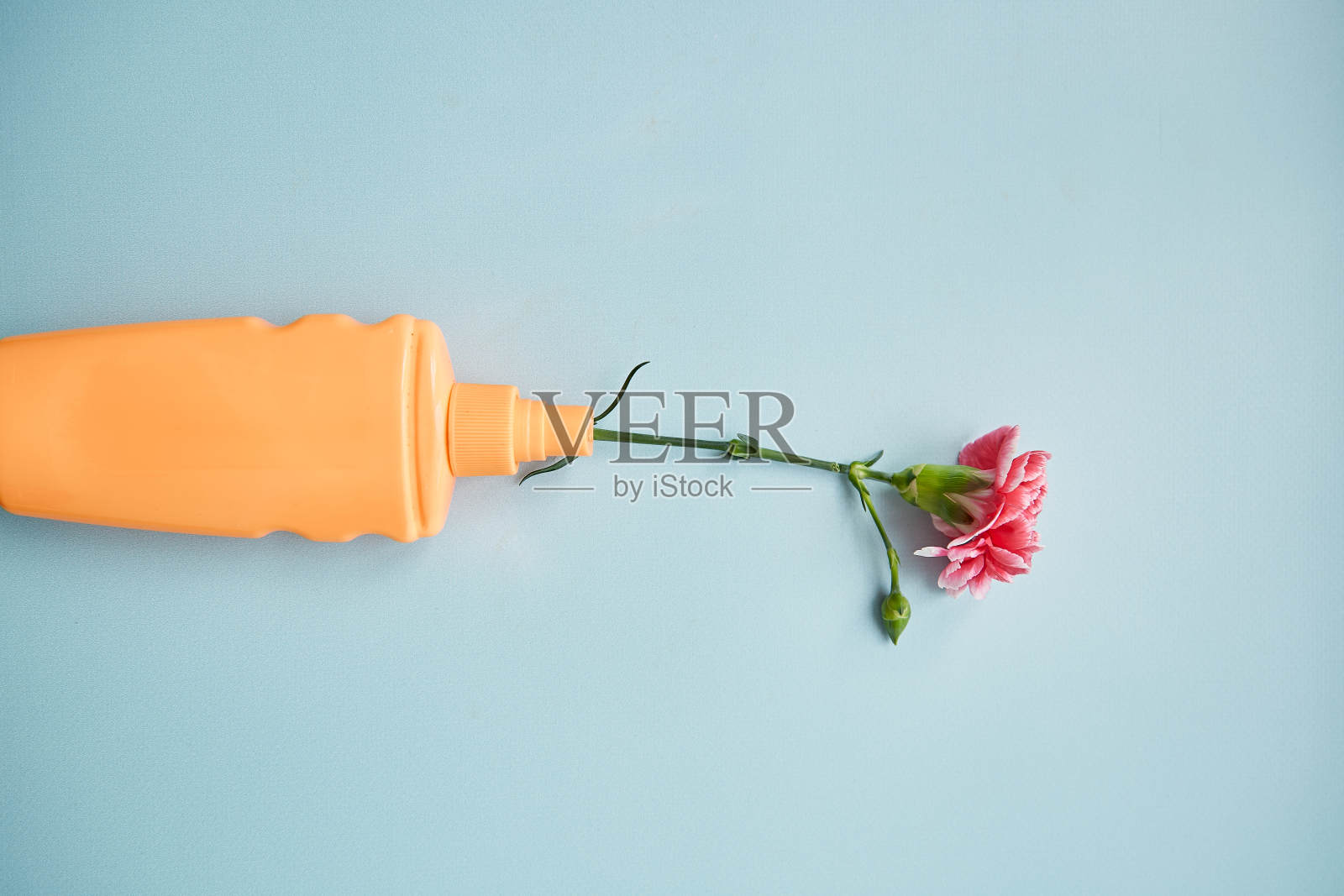 护肤亮肤化妆瓶模拟。橙色美容产品在蓝色背景与花朵装饰。保健美容产品照片摄影图片