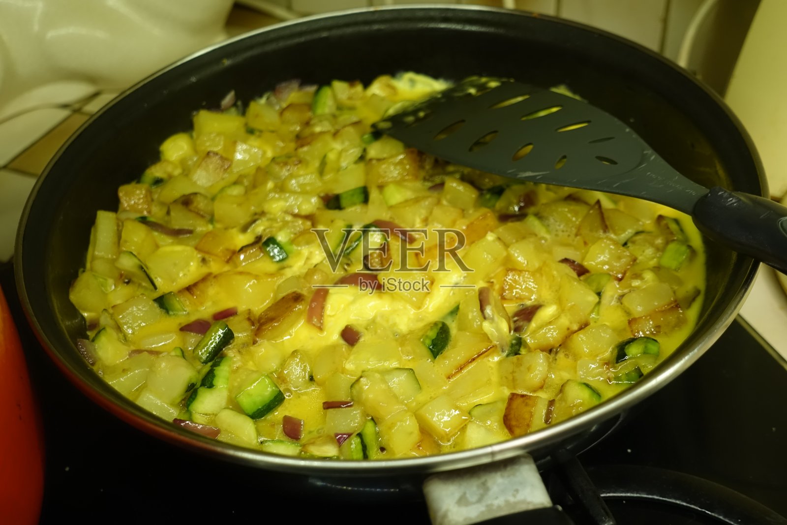 土豆和西葫芦煎蛋卷在煎锅里切成方块照片摄影图片