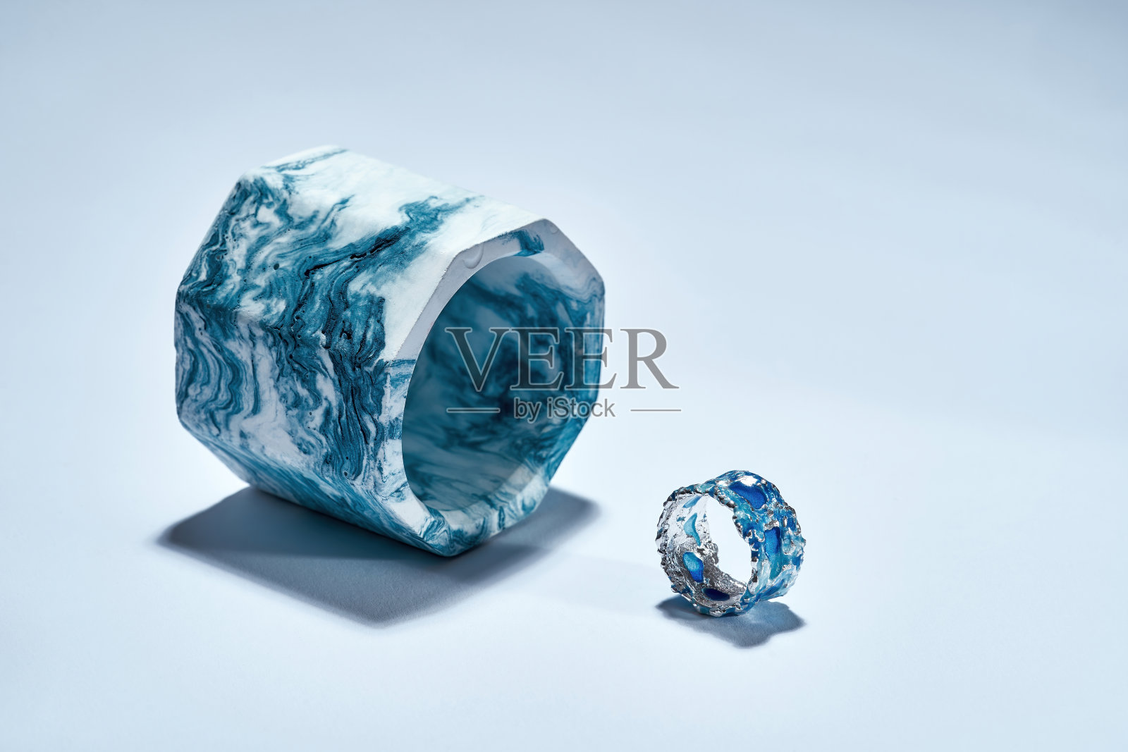 工作室拍摄了一个由银色金属和蓝色搪瓷组成的环，工业蓝色大理石混凝土元素被隔离在光的背景上照片摄影图片