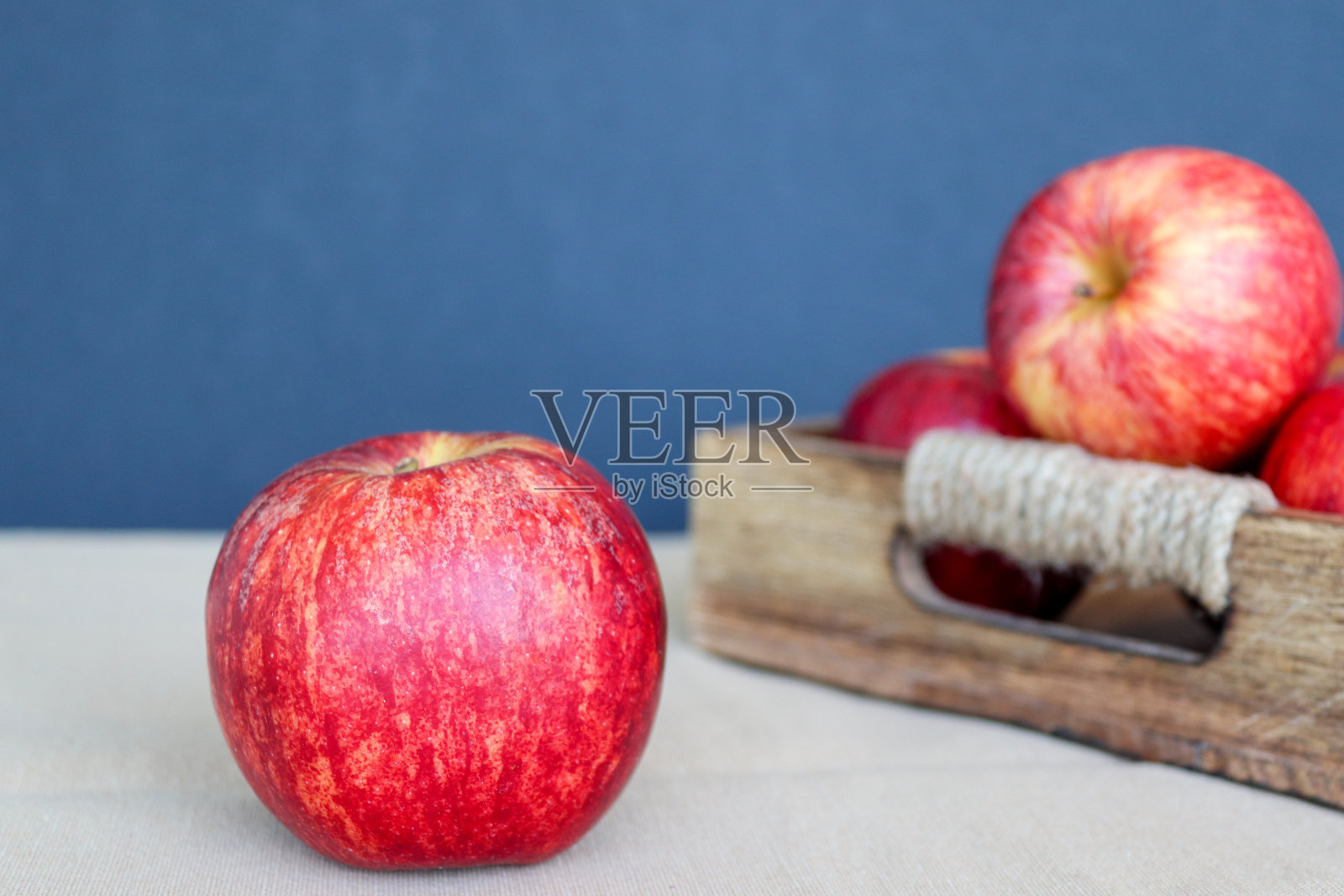 一个苹果放在一个装着苹果的木箱前面的桌子上照片摄影图片