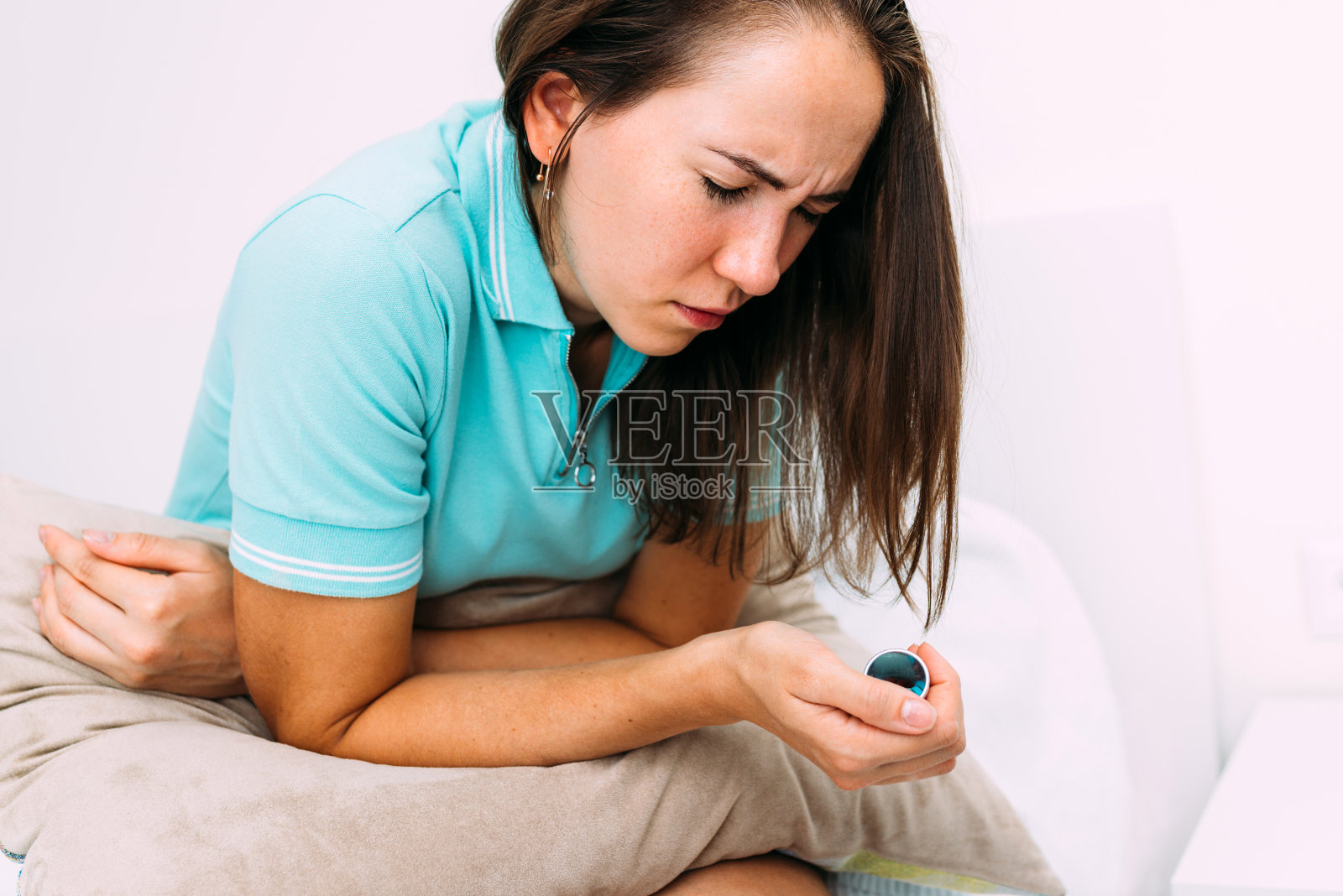 妇女因胃痛而弯腰，手中拿着药照片摄影图片