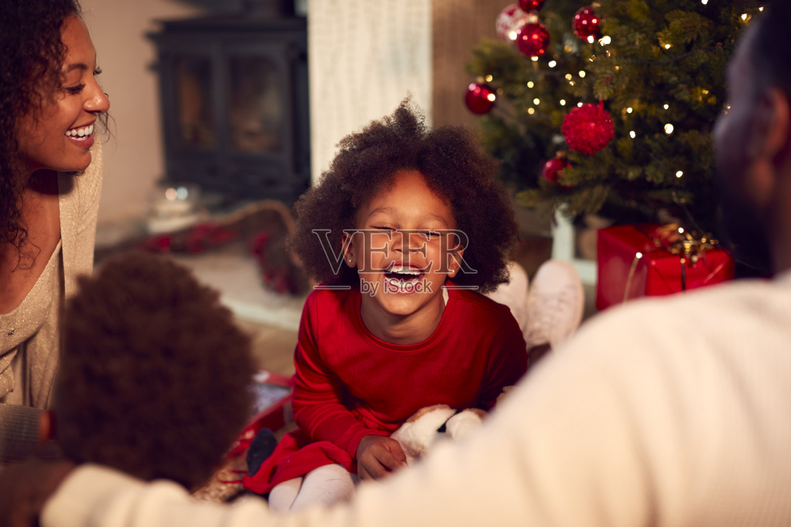 家人在家里的圣诞树旁交换和打开礼物照片摄影图片