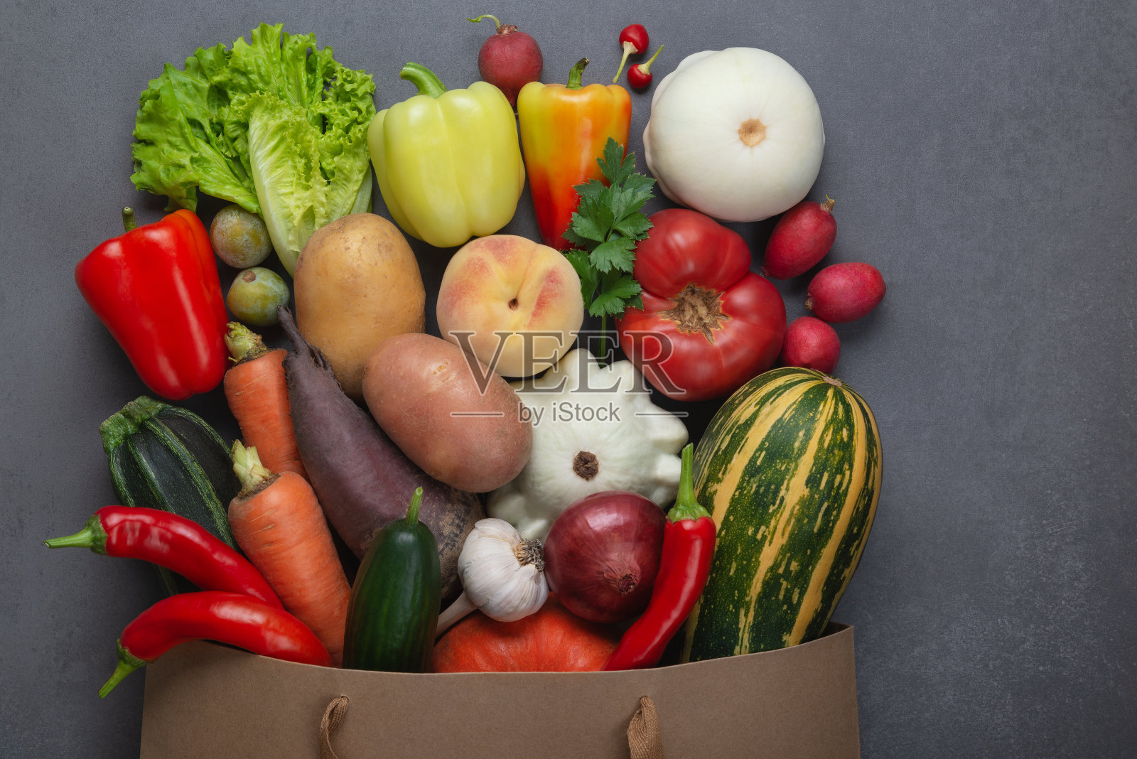 健康食品的背景。健康素食纸袋蔬菜和水果在灰色，复制空间，横幅。购物食品超市和清洁素食饮食的概念。照片摄影图片