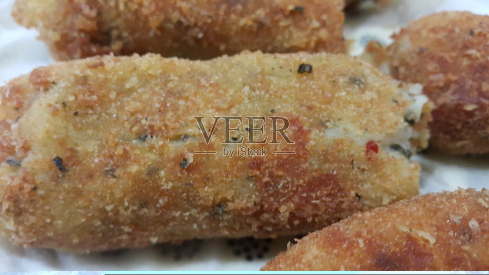 香辣美味的炸丸子放在陶瓷盘子里，铺在木地板上照片摄影图片