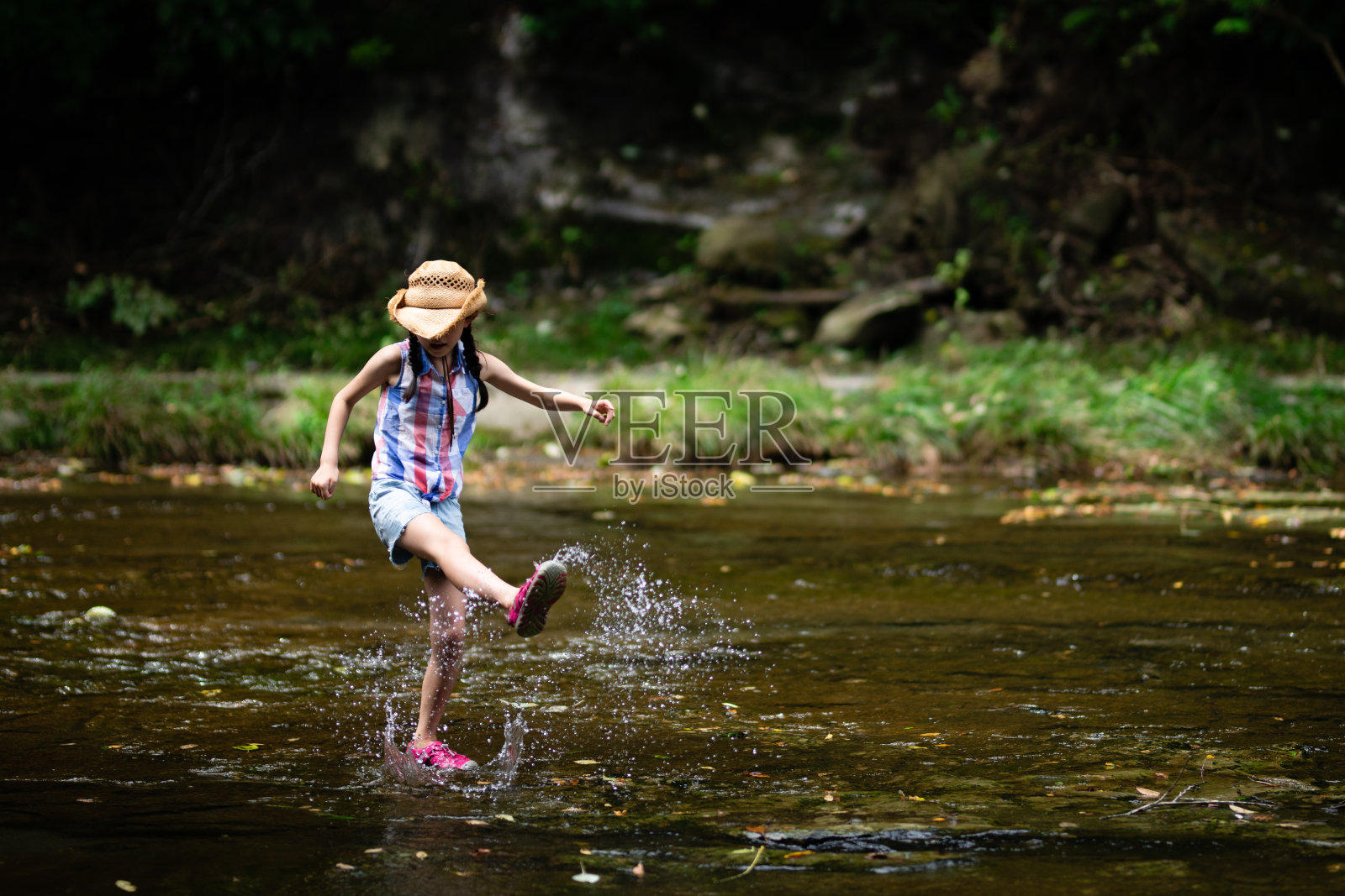 一个孩子在山溪里踢水照片摄影图片