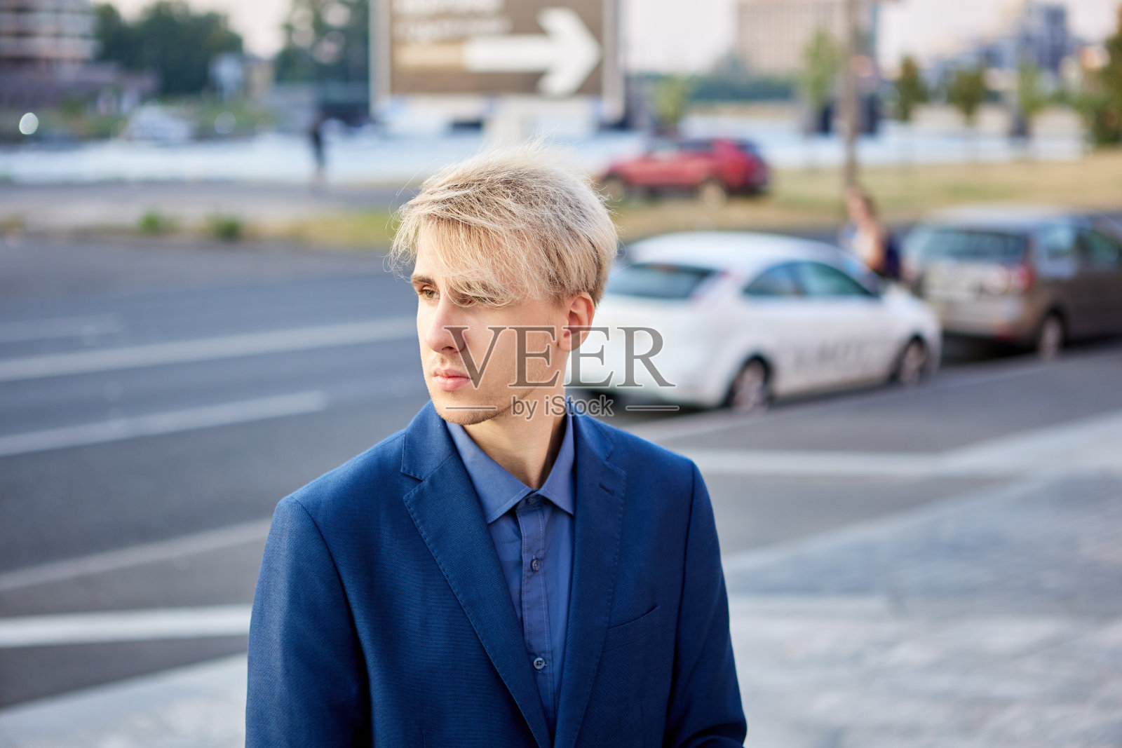 夏天，西装革履的经理站在车流旁。照片摄影图片