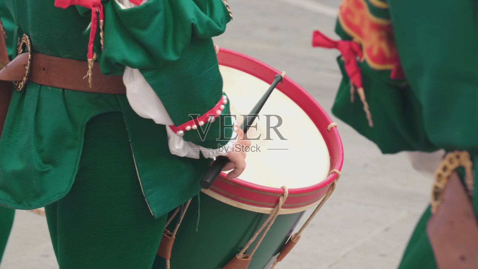 身穿传统服装的鼓手在街头庆祝活动中打鼓照片摄影图片