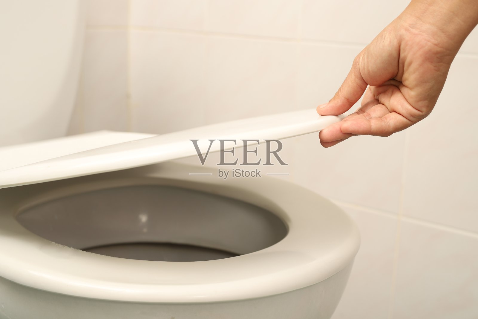 女人用手打开马桶盖照片摄影图片
