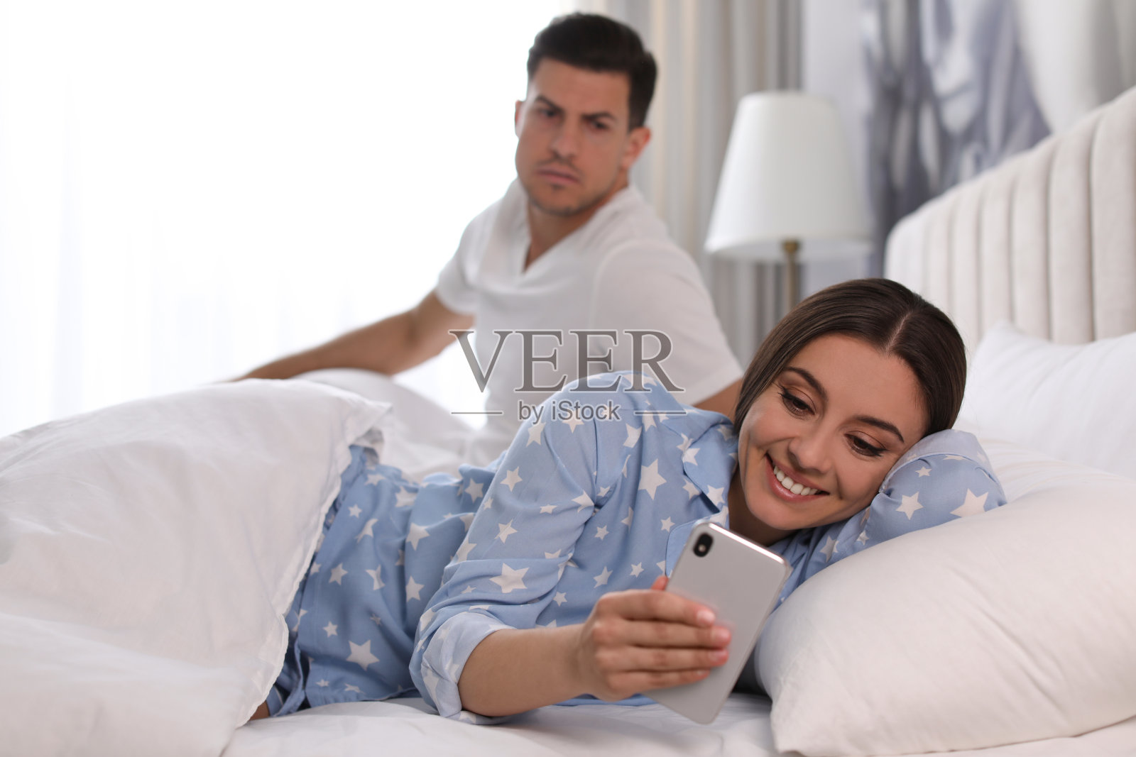 在家偷看女友手机的多疑男子嫉妒的关系照片摄影图片