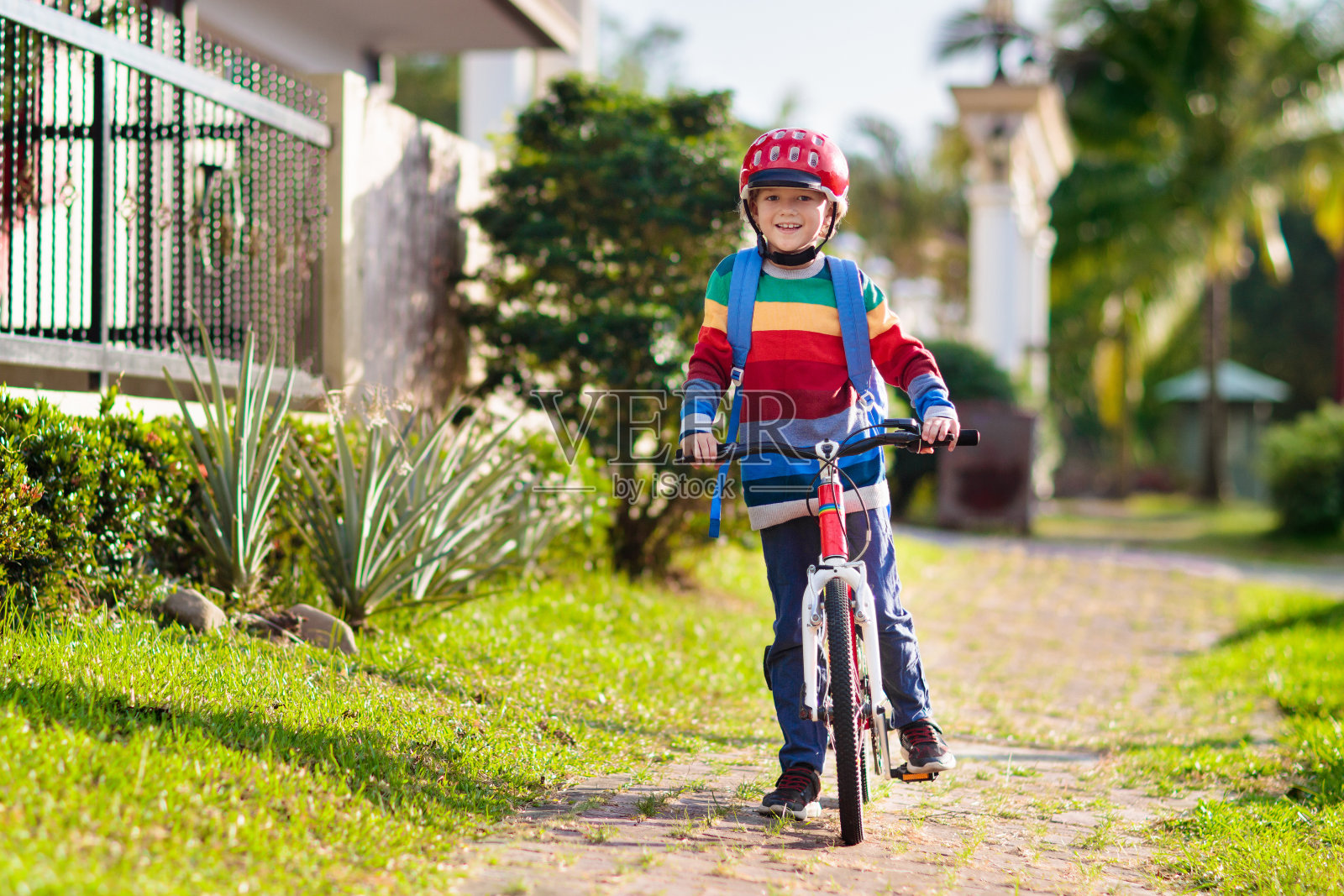 男孩骑自行车上学。孩子们骑自行车。照片摄影图片
