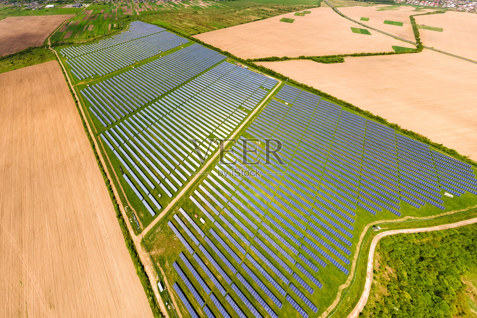 鸟瞰图的大型可持续发电厂与许多排太阳能光伏电池板生产清洁的生态电能。零排放概念的可再生电力。照片摄影图片