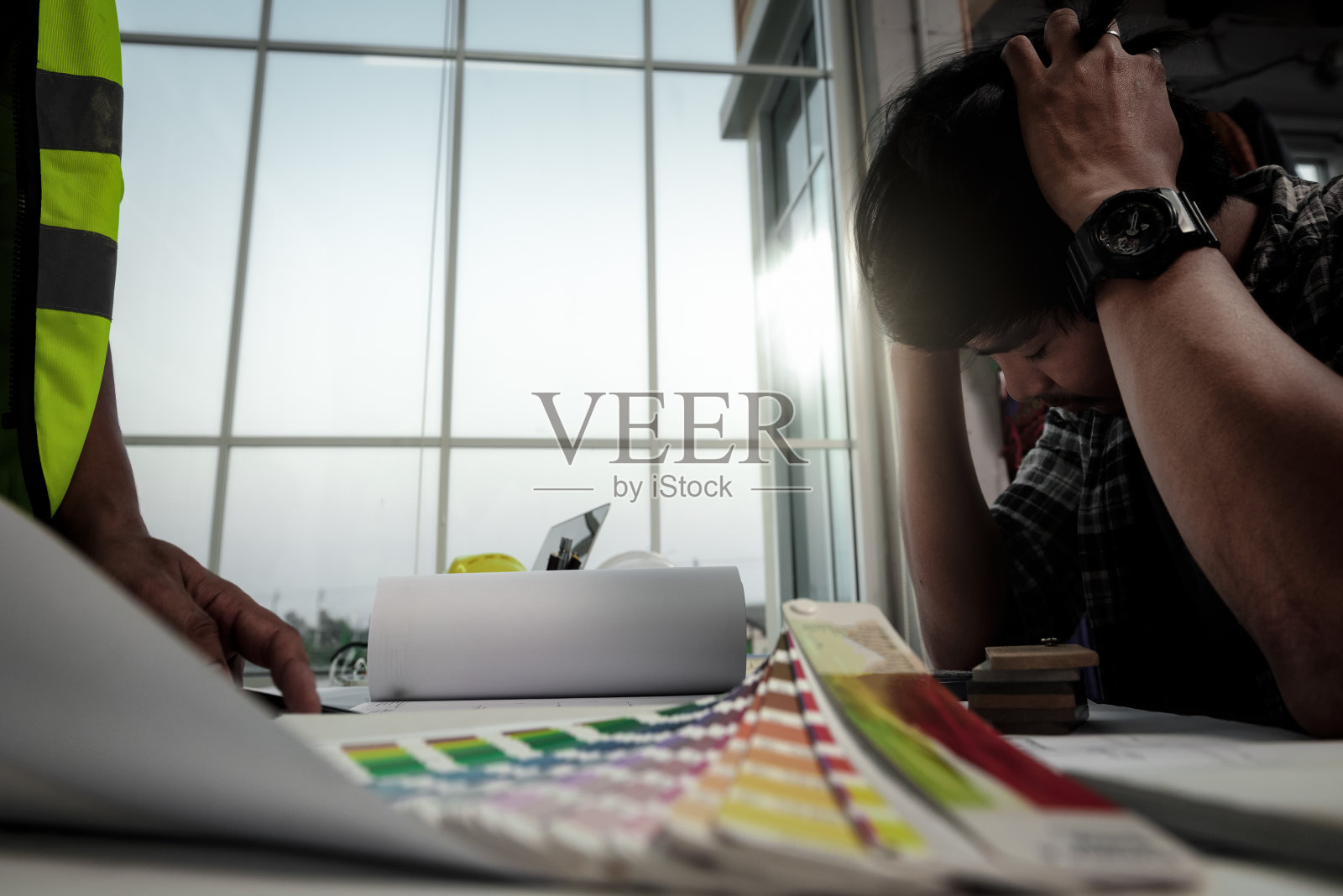 紧张的工程师，人们在办公室开会时惊慌失措，年轻的员工在桌子前手放在头上压力很大。照片摄影图片