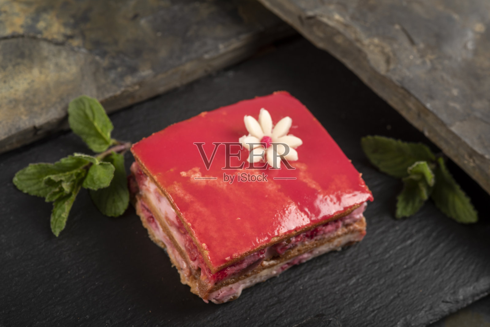 自制的蛋糕，用粉红色的釉料和杏仁糖花装饰。照片摄影图片