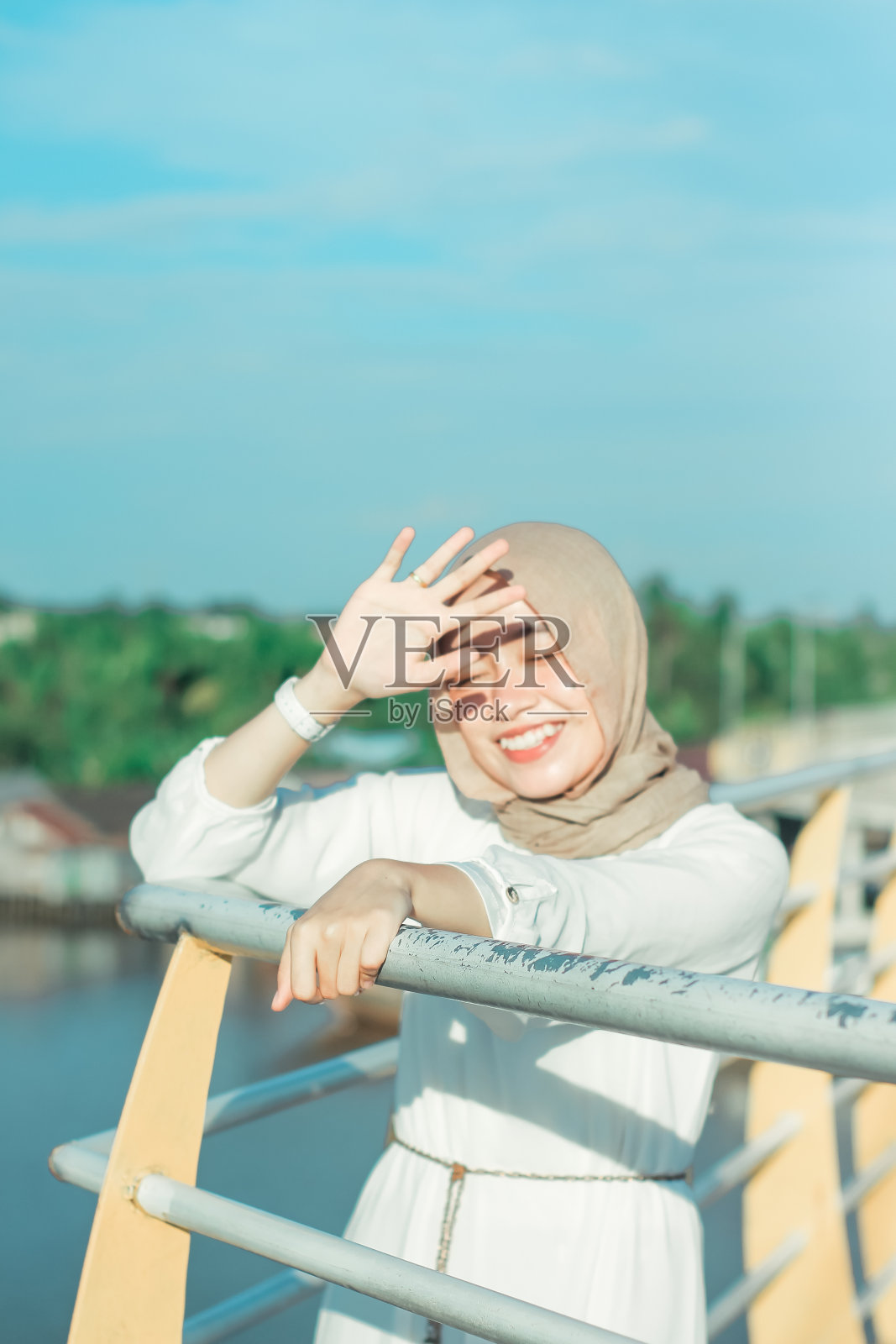 年轻女子在公园桥边笑着照片摄影图片