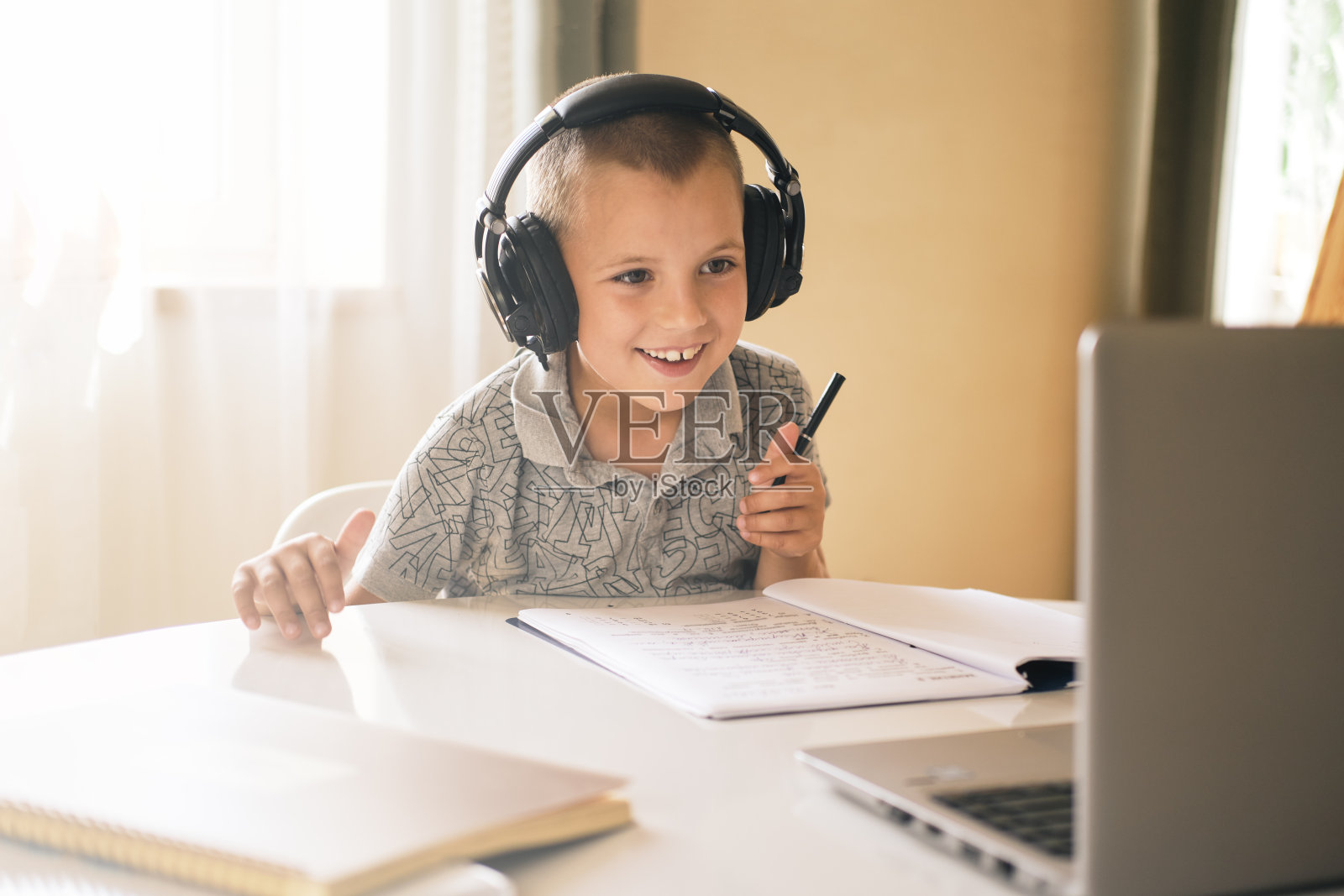 一名小学生正在使用笔记本电脑。照片摄影图片