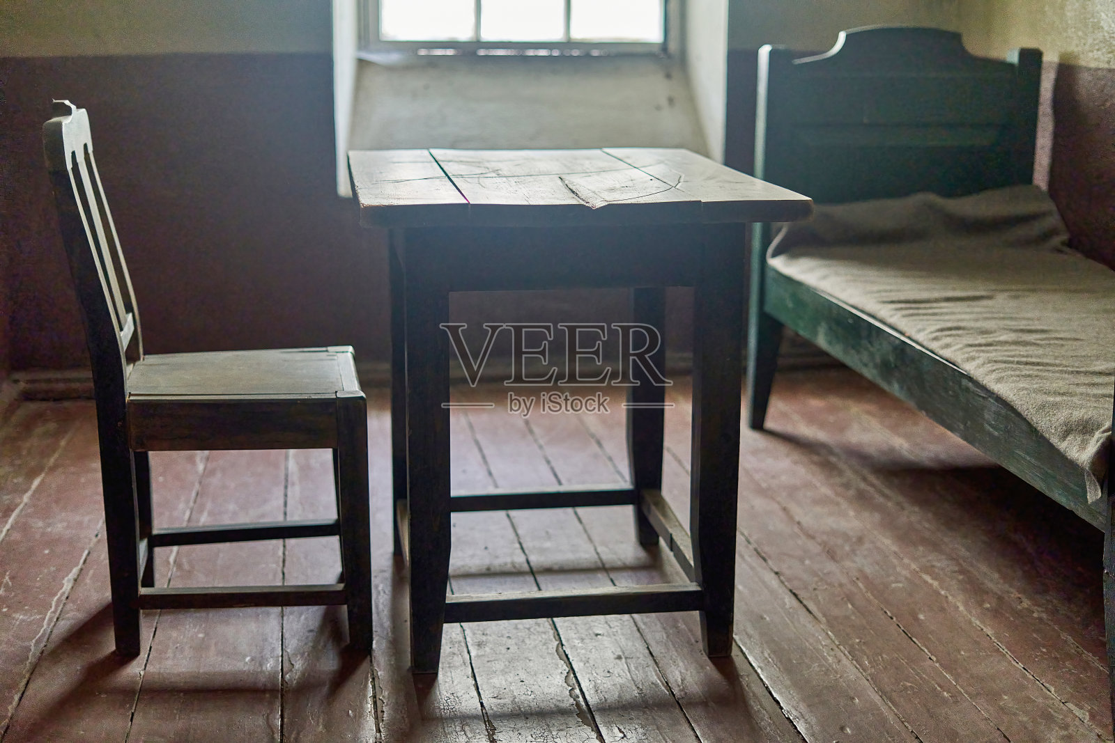 牢房内部有木制家具，光线从窗户透进来照片摄影图片
