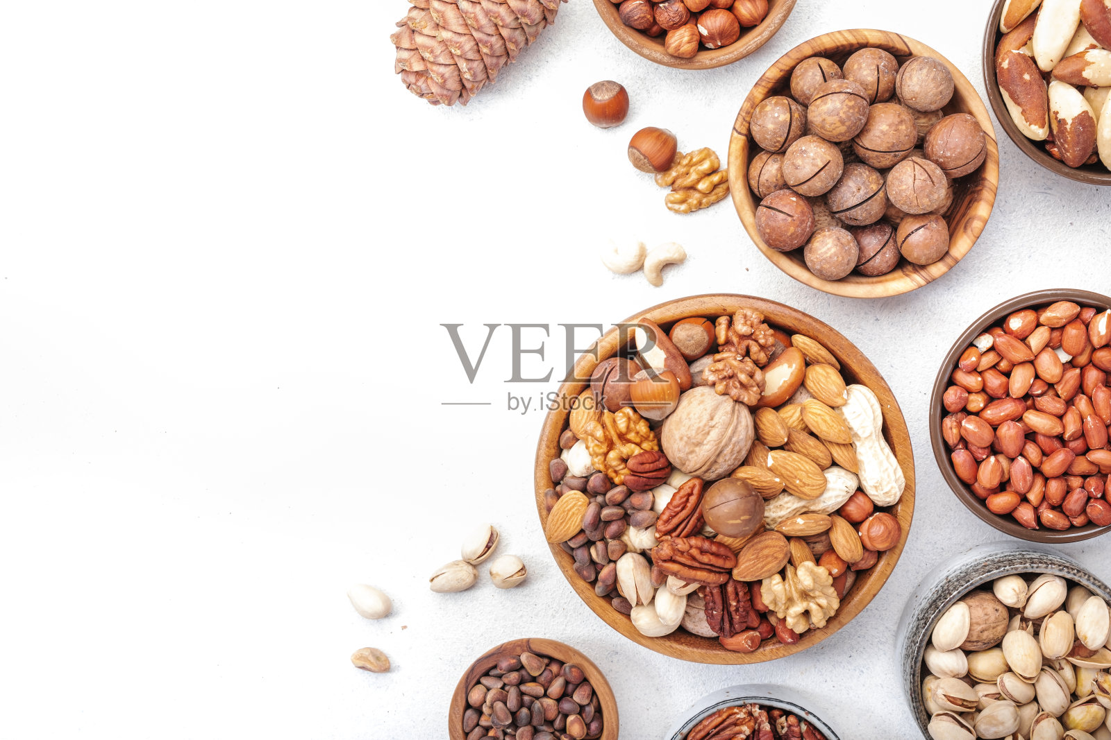 坚果混合在碗里。杏仁、榛子、核桃等。健康食品小吃组合在白色的桌子上，俯视图，复制空间照片摄影图片
