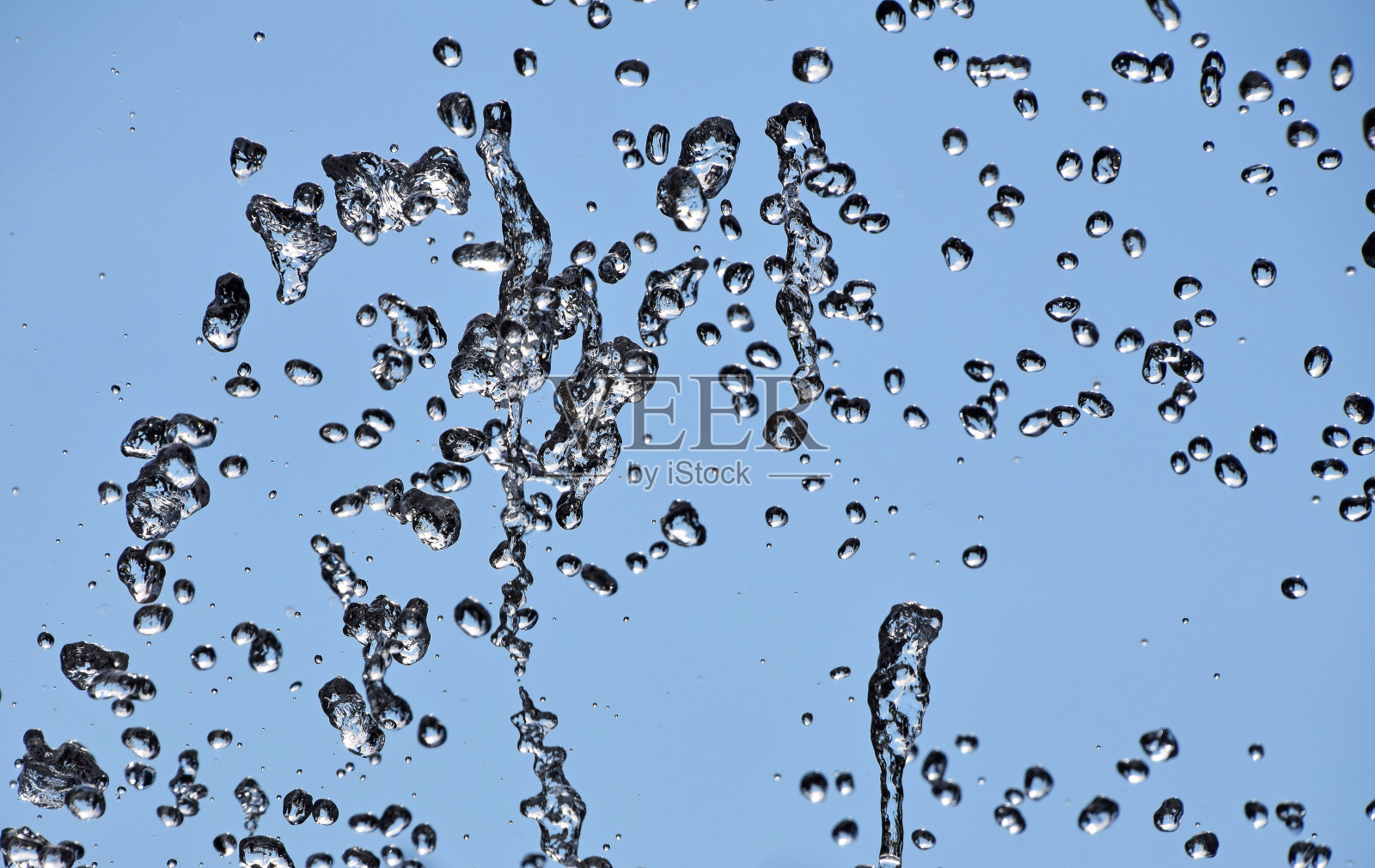 喷泉的水滴在蓝天上流淌照片摄影图片